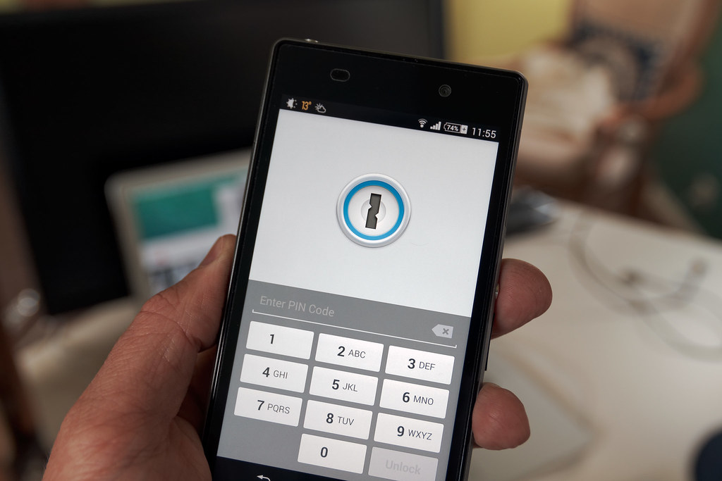 Un téléphone affichant un code de vérification temporaire à côté d'un écran de connexion
