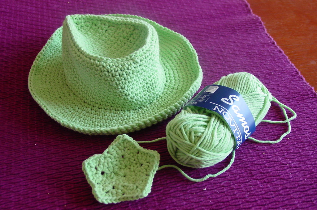 A crochet hook and a ball of yarn on a table