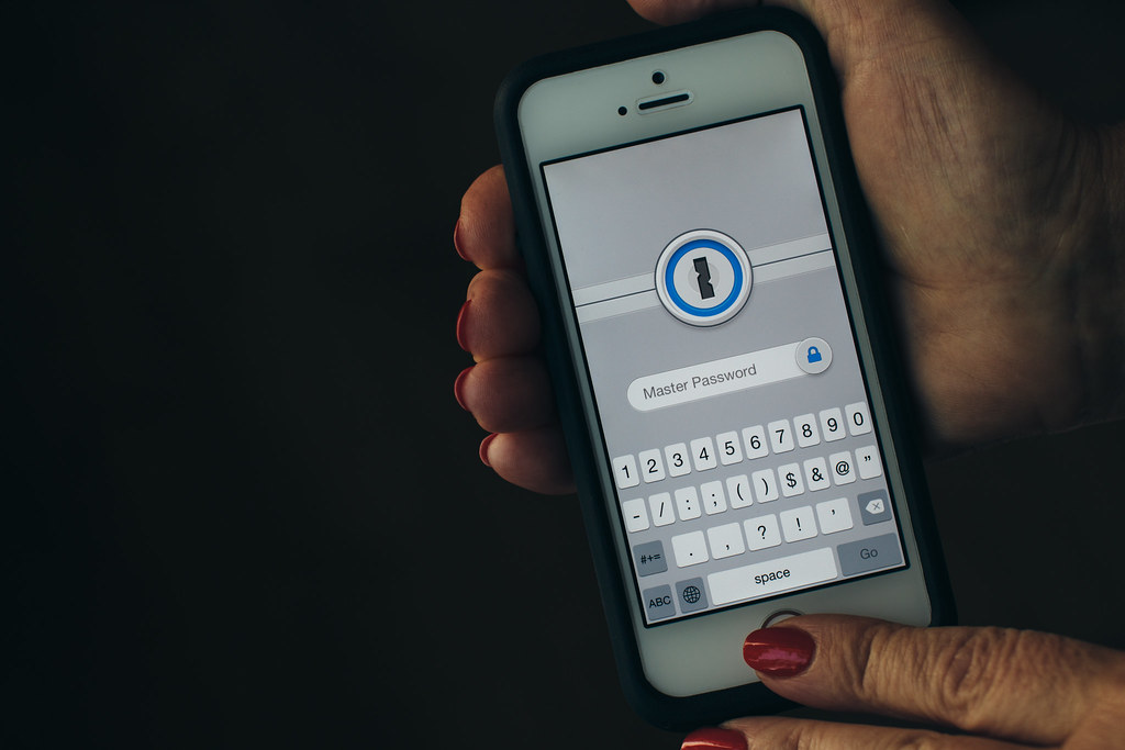 Un teléfono mostrando un código de verificación temporal junto a una pantalla de inicio de sesión
