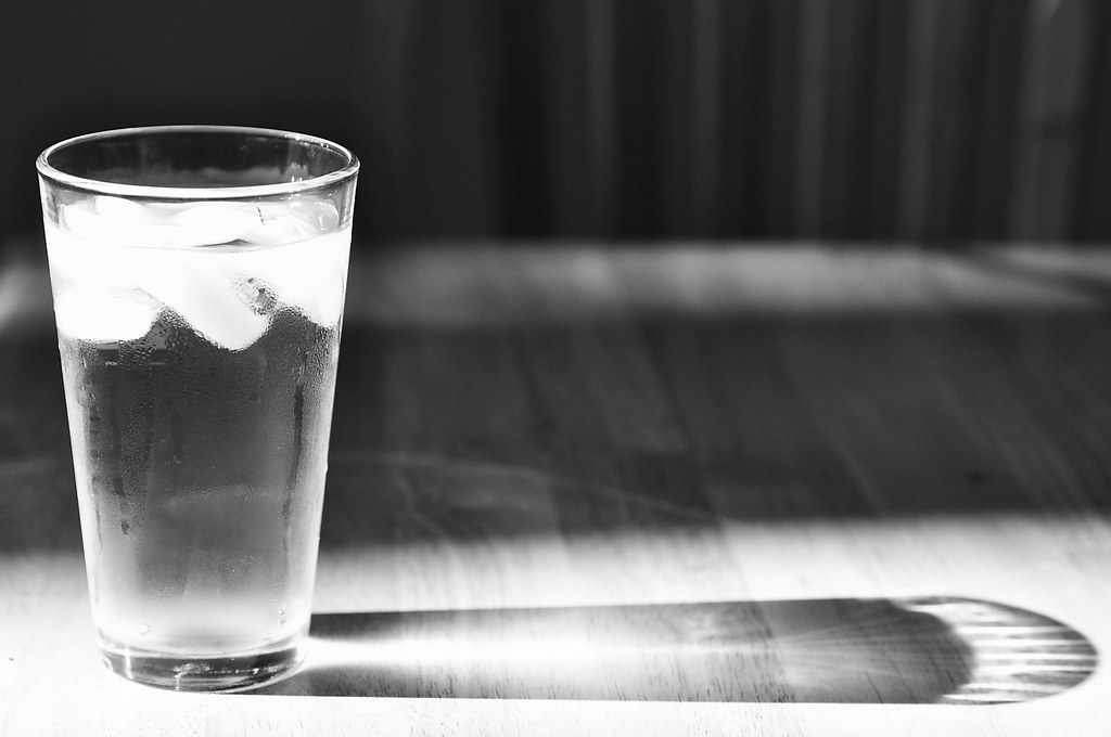 Ein Glas Wasser auf einem Tisch im Tageslicht